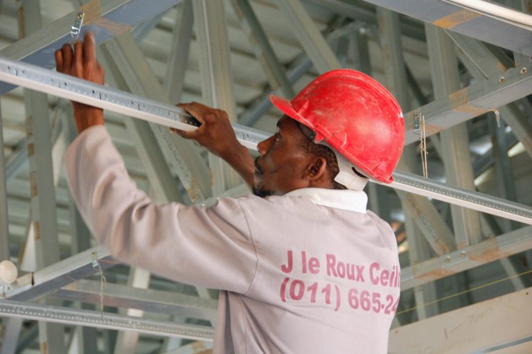 J le Roux Ceilings installer levelling a suspended ceiling grid frame on site